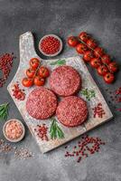 Fresco crudo suelo carne de vaca hamburguesa empanada con sal y especias foto
