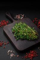 Empty wooden cutting board with thyme, spices, salt and herbs photo