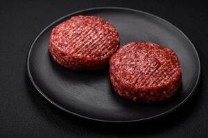 Fresh raw ground beef burger patty with salt and spices photo