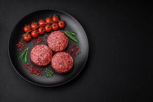 Fresh raw ground beef burger patty with salt and spices photo