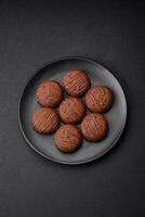 Delicious sweet chocolate cookies on a black ceramic plate photo