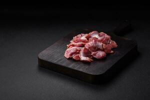 Raw chicken or turkey gizzards with salt, spices and herbs photo