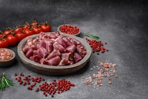 Raw chicken or turkey hearts with salt, spices and herbs photo