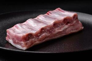 Raw pork ribs with meat with salt, spices and herbs photo