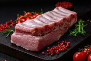 Raw pork ribs with meat with salt, spices and herbs photo