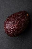 Fresh, ripe, soft brown colored avocado on a dark concrete background photo