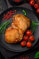 Delicious juicy chicken thighs baked with salt, spices and herbs in a ceramic plate photo