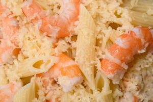 Delicious fresh penna pasta with shrimp, sauce, cheese, salt and spices photo