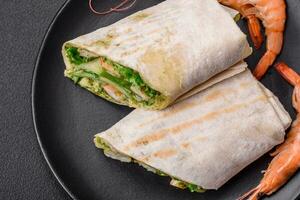 Delicious fresh roll with shrimps, tomatoes, lettuce and cucumber in pita bread photo