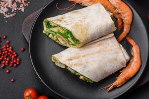 Delicious fresh roll with shrimps, tomatoes, lettuce and cucumber in pita bread photo