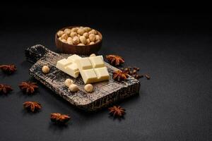 Delicious sweet white chocolate broken into cubes on a wooden cutting board photo