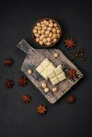 Delicious sweet white chocolate broken into cubes on a wooden cutting board photo