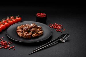 Chicken hearts fried in soy sauce with salt and spices in a plate photo