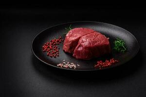 Raw beef eye steak round with salt, spices and herbs photo