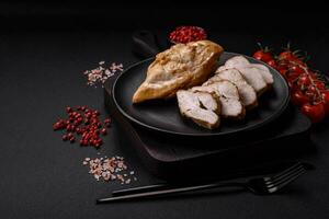 Delicious fresh grilled chicken fillet with salt, spices and herbs on a ceramic plate photo