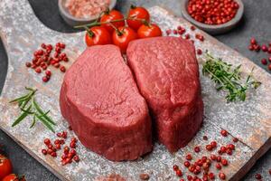 Raw beef eye steak round with salt, spices and herbs photo