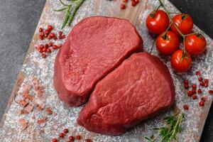 Raw beef eye steak round with salt, spices and herbs photo