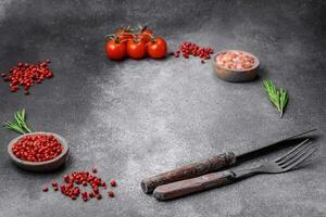 Ingredients, spices, salt, tomatoes, rosemary and cutlery knife and fork photo