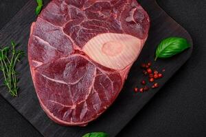 Fresh beef ossobuco steak with salt, spices and herbs photo