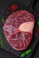 Fresh beef ossobuco steak with salt, spices and herbs photo