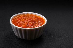 Delicious spicy tomato sauce with pepper, garlic, salt, spices and herbs photo