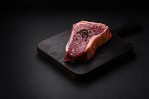 Fresh juicy raw new york beef steak with salt, spices and herbs photo