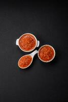 delicioso picante tomate salsa con pimienta, ajo, sal, especias y hierbas foto