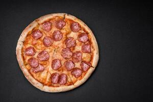 Tasty fresh pizza with salami, cheese, tomatoes, spices and salt photo