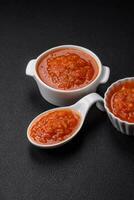 Delicious spicy tomato sauce with pepper, garlic, salt, spices and herbs photo