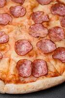 Tasty fresh pizza with salami, cheese, tomatoes, spices and salt photo