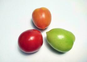 Tomates de diferente colores aislado en blanco antecedentes. el color varía dependiente en el la licenciatura de madurez. foto