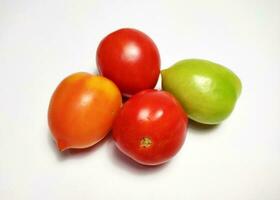 Tomates de diferente colores aislado en blanco antecedentes. el color varía dependiente en el la licenciatura de madurez. foto