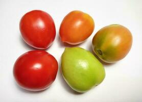 Tomates de diferente colores aislado en blanco antecedentes. el color varía dependiente en el la licenciatura de madurez. foto