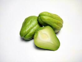 Whole chayote and chayote cut in half, white background. photo