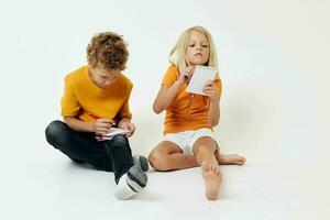 Boy and girl on the floor with notepads and pencils isolated background unaltered photo