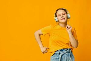 gracioso niña escuchando a música en auriculares juventud estilo amarillo antecedentes inalterado foto