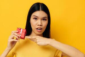 woman with Asian appearance holding a gift box in his hands posing isolated background unaltered photo