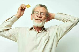 Elderly man combing hair with yellow comb in studio photo