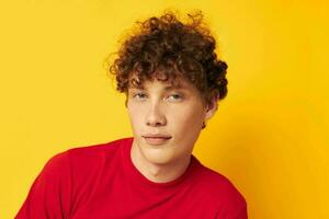 portrait of a young curly man red t shirt fun posing casual wear isolated background unaltered photo