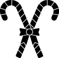 Black and White candy cane with bow. Glyph icon or symbol. vector