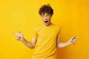 guy with red curly hair yellow t-shirt glasses fashion hand gestures yellow background unaltered photo