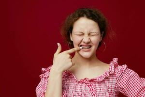 bonito mujer en rosado camisa posando emociones rojo antecedentes inalterado foto