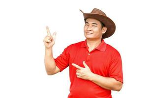 Handsome Asian man wears hat, red shirt, point fingers up, feels confident, isolated on white background. Copy space of adding text or advertisement. photo