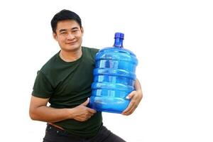 Handsome Asian water delivery courier man is holding a bottle . Thumbs up, isolated on white background. Concept, Drinking water delivery service. photo