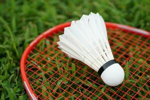 White shuttlecock on badminton racket. Concept, sport equipment, doing sport and exercise for health, recreation activity. photo