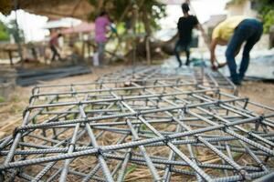 workers are  preparing steel poles for building photo