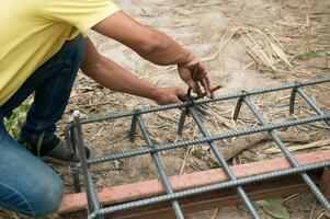 workers are  preparing steel poles for building house photo