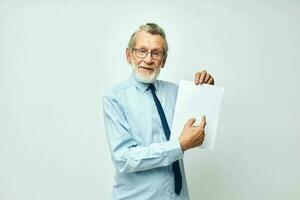 mayor canoso hombre participación documentos con un sábana de papel ligero antecedentes foto