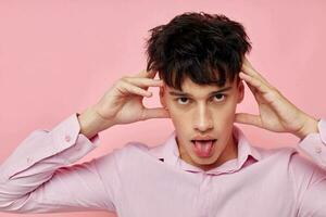 handsome guy in a pink shirt gesturing with his hands isolated background unaltered photo