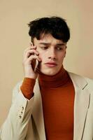 A young man mobile phone in the hands of communication in a suit fashion light background unaltered photo